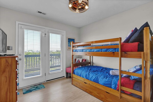Trade places for the bottom bunk this time — French doors open right onto a balcony with a marsh view for whoever's up early.