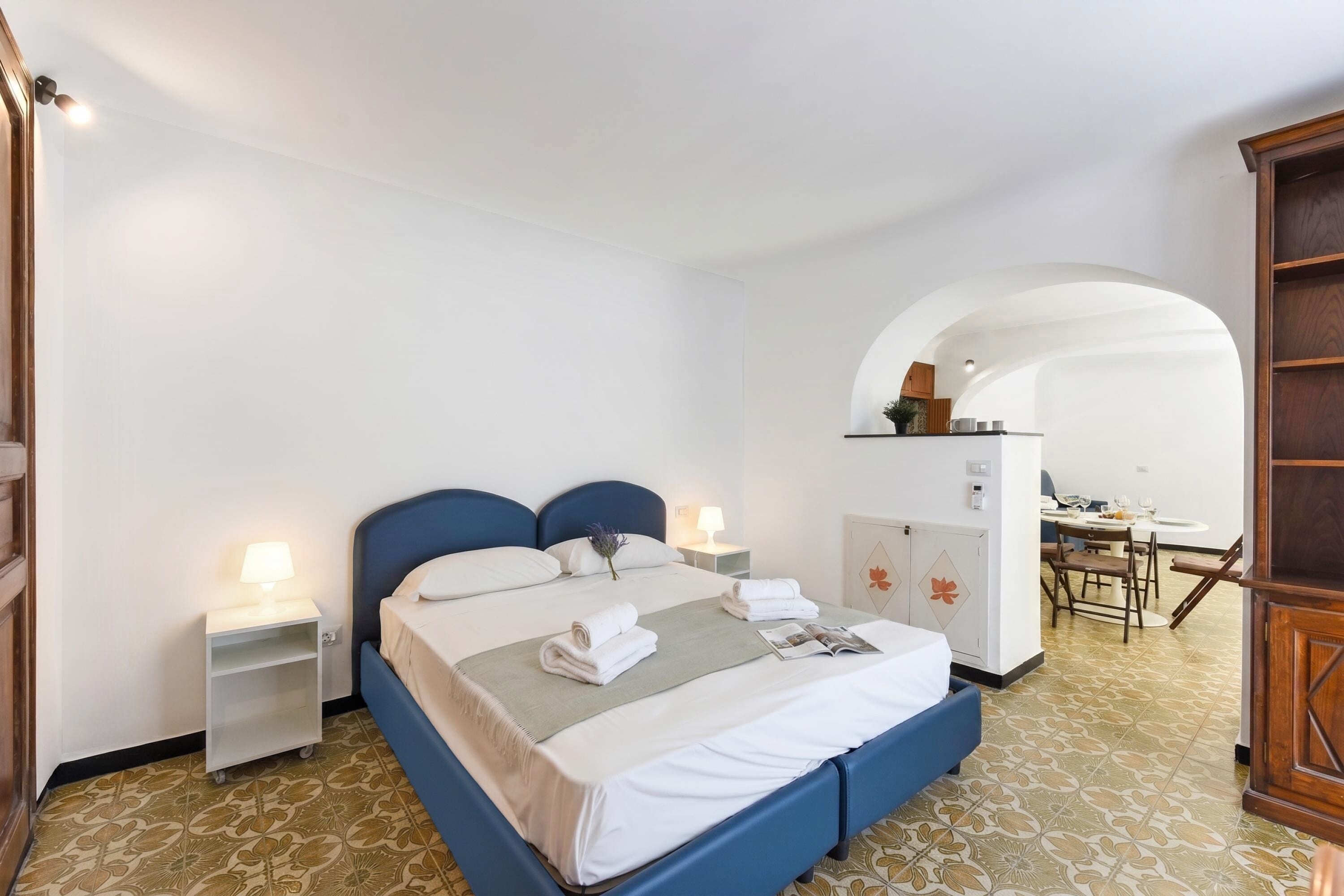 A hotel room with a bed, bedside tables, a desk, and a chair.