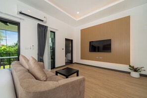 Suite superior, vista al jardín | Área de sala de estar