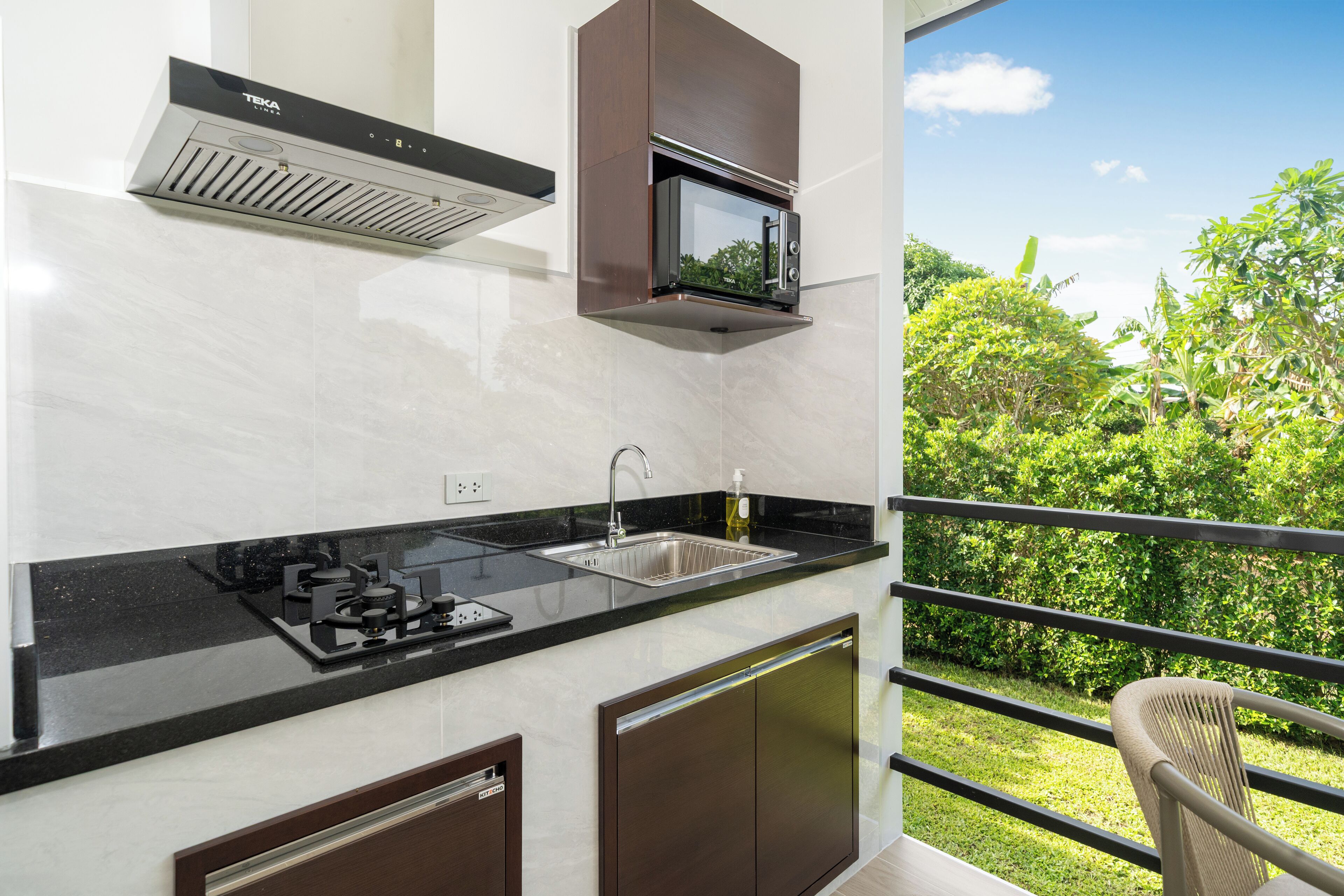 A modern kitchen with a built-in microwave, stainless steel sink, and a gas stove.