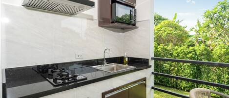 A modern kitchen with a built-in microwave, stainless steel sink, and a gas stove.