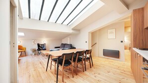 A modern interior with a dining area, a sofa, and a kitchen. - Charming Apt - 2bd/10p - Buttes aux Cailles (Paris)