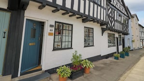 A traditional half-timbered building with a blue door, numbered 48, and labeled as 'Middle Cottage'.