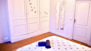 Een slaapkamer met een bed, een kledingkast en een wand met vlinderdecoraties.