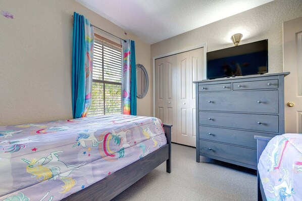 Une chambre à coucher avec un lit, une commode et un téléviseur.
