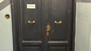 A dark wooden double door with a brass handle and a keyhole, and a sign above the door. - Termini Apartment by Ghor (Rome)