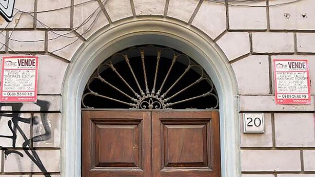 A double wooden door with brass knockers, a number '20' plaque, and two 'VENDES' signs on the wall. - Termini Apartment by Ghor (Rome)