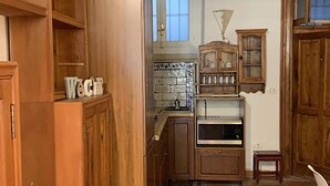 Una cucina rustica con mobili in legno, zoccolo a mosaico e un piccolo forno.