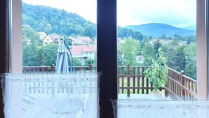 A room with a view of a mountainous landscape, a balcony with a railing, and a potted plant. - Charming Cottage with Vosges Mountain Views | Perfect for Walkers | Pets | WiFi  (Neuve-Église)