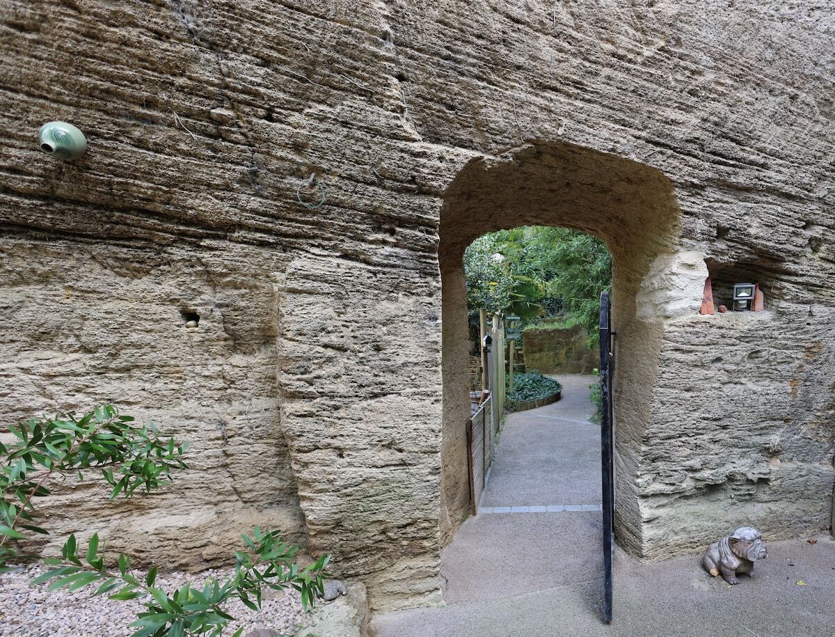 Un arco de piedra que da acceso a un camino.