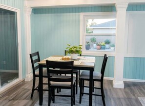 A dining area with a table, chairs, and potted plants.