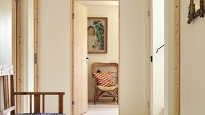 A hallway with a wooden bench, a wicker chair, and a painting on the wall. - Spectacular 6-bed house in beautiful manor park (Mariefred)