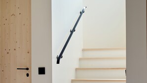 A staircase with wooden steps and a black handrail, leading to a door with a wooden frame. - Spectacular 6-bed house in beautiful manor park (Mariefred)