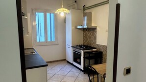 A kitchen with a tiled floor, a stove, a sink, and a window. - Casa dei fiori appartamento  6 persone - by Ghor (Rome)