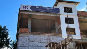 Edificio de varios pisos en construcción con un letrero de B&B Residency que indica que es un alojamiento y ofrece servicios de comida.