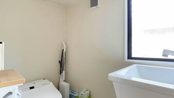 A compact bathroom with a toilet, a sink, and a window.