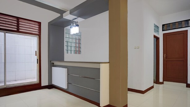 Un pasillo limpio y moderno con suelo de baldosas, una puerta de madera y un ventanal con diseño de vidrio esmerilado.