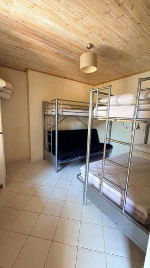 A bunk bed room with a wooden ceiling and tiled floor. - Casa Paulo: Discover the Magic of Southern Italy (Calabria)