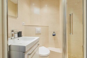 Appartement | Badkamer | Een haardroger, handdoeken, shampoo