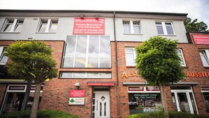 A multi-story building with commercial signage, including a water damage repair service and a parkette company.