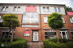 A multi-story building with commercial signage, including a water damage repair service and a parkette company.