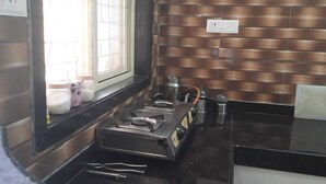 Una cocina con estufa a gas, ventana y revestimiento de pared de ladrillo.