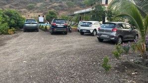 Un aparcamiento de grava con cuatro coches estacionados.