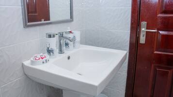 Chuveiro, toalhas de banho, sabonete, papel higiênico