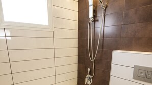 Ein Badezimmer mit Badewanne, Toilette und Dusche.
