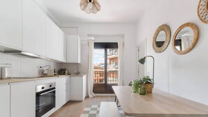 A modern kitchen with white cabinets, a wooden countertop, and a checkered floor.
