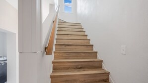 A wooden staircase with white walls and a small window at the top. - Pet-Friendly, Stylish Home w/ Backyard Oasis (Santa Maria)
