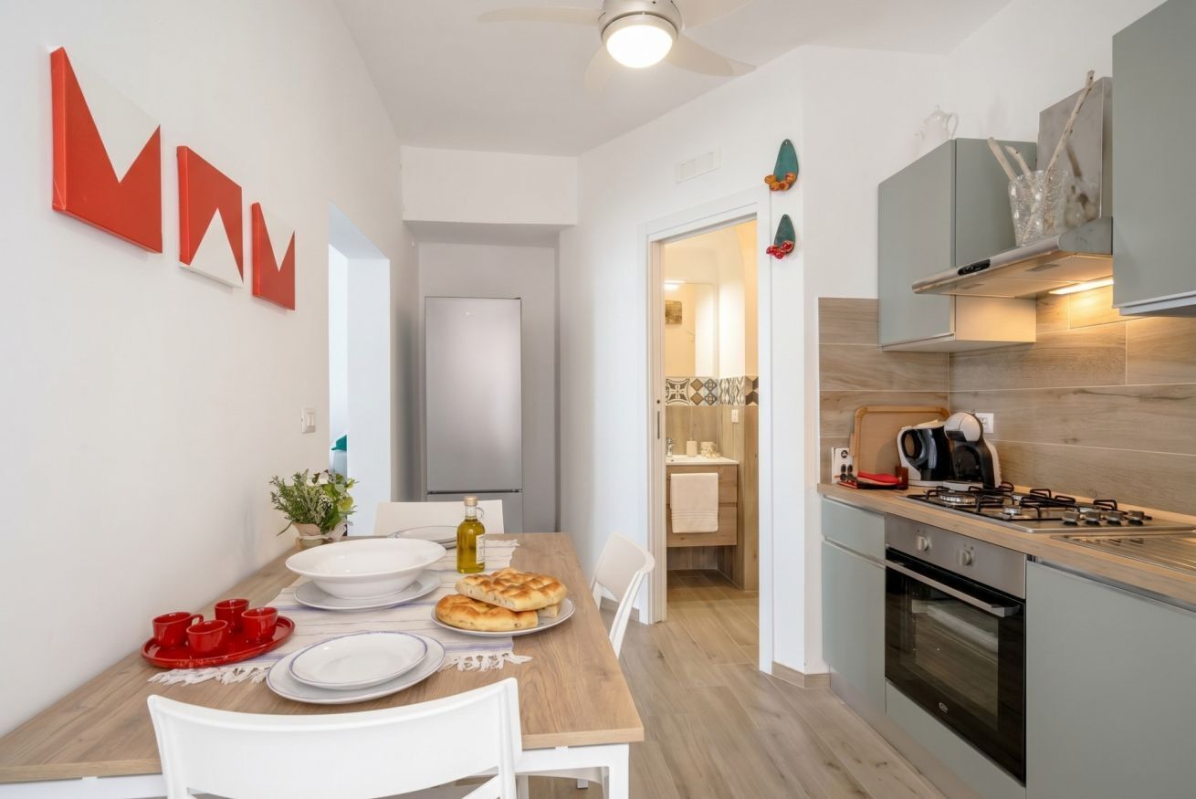 Una cucina moderna con zona pranzo, forno a vista e un piano di lavoro con macchina del caffè.
