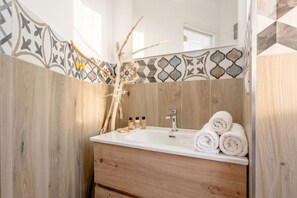 A bathroom with a wooden vanity, a sink, and a mirror. - Gabbiano 2 - Sea Loft  (Bari)