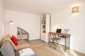 A modern living room with a sofa, a desk, a bookshelf, and a lamp. - Gabbiano 2 - Sea Loft  (Bari)