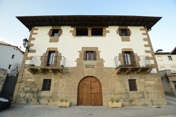 Un edificio in pietra con una porta di legno e due balconi.