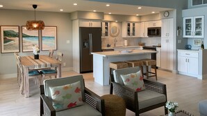 A modern kitchen with a central island, white cabinetry, and a ceiling fan. - Ma'alaea Surf, Unit A4-2 BR Ground Floor Beachfront Condo, AC, Wi-Fi, Pool (Kihei)