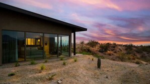 A modern building with large glass windows, a flat roof, and a desert landscape in the background. - Paradise Canyon-Heated Pool-Mountain View-Estate 2 (Fort Mcdowell)