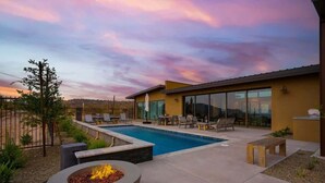 A modern outdoor pool area with a fire pit, lounge chairs, and a clear view of the surrounding landscape. - Paradise Canyon-Heated Pool-Mountain View-Estate 2 (Fort Mcdowell)