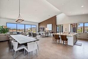 A spacious living area with a dining table, sofas, and a kitchen island. - Paradise Canyon-Infinity Pool-Mnt Views-Estate 3 (Fort Mcdowell)