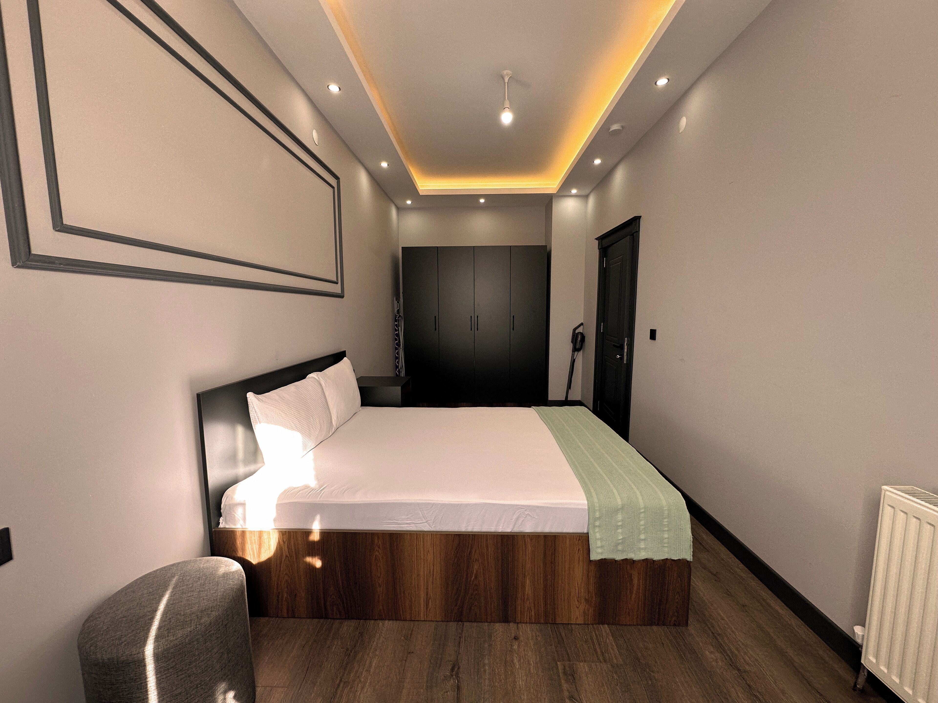 Un dormitorio moderno con una cama grande, un armario y un radiador.