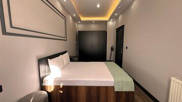 Un dormitorio moderno con una cama grande, un armario y un radiador.