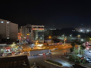 A multi-story building with a 'Plaza' sign, surrounded by a busy street with cars and a few pedestrians. - Sarayim Rezidans (Tatvan)