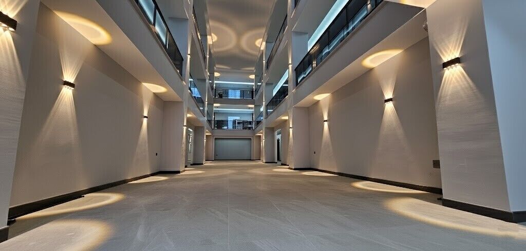 A spacious, multi-level corridor with modern lighting fixtures and a clean, minimalist design.