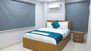 A neatly made bed with a wooden frame, white bedding, and teal accents. - Single Room in Secure Apartment – Akoka Yaba Lagos (Yaba)