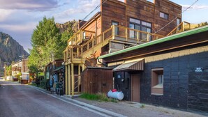 A rustic building with a wooden facade, a balcony, and a 'NO PARKING' sign.