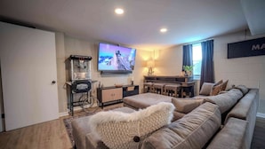 Una sala de estar moderna con un sofá, un televisor, un mueble bajo y una silla de ruedas.