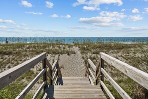 A wooden boardwalk leading to a beach with sand and sparse vegetation. - Holliday Haven #200 - Oceanfront Escape in Topsail Beach, Sleeps 9! (Topsail Beach)