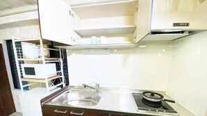 Una cocina compacta con lavamanos, estufa y armarios.