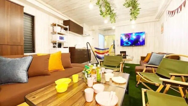 Una sala de estar moderna con un sofá marrón, una mesa de centro de madera y un televisor de pantalla plana montado en la pared.