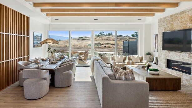 A modern living room with a large TV, fireplace, and a dining area with a view of the outdoors. - Luxury Retreat 12 miles from Park City - Ameyalli (Midway)